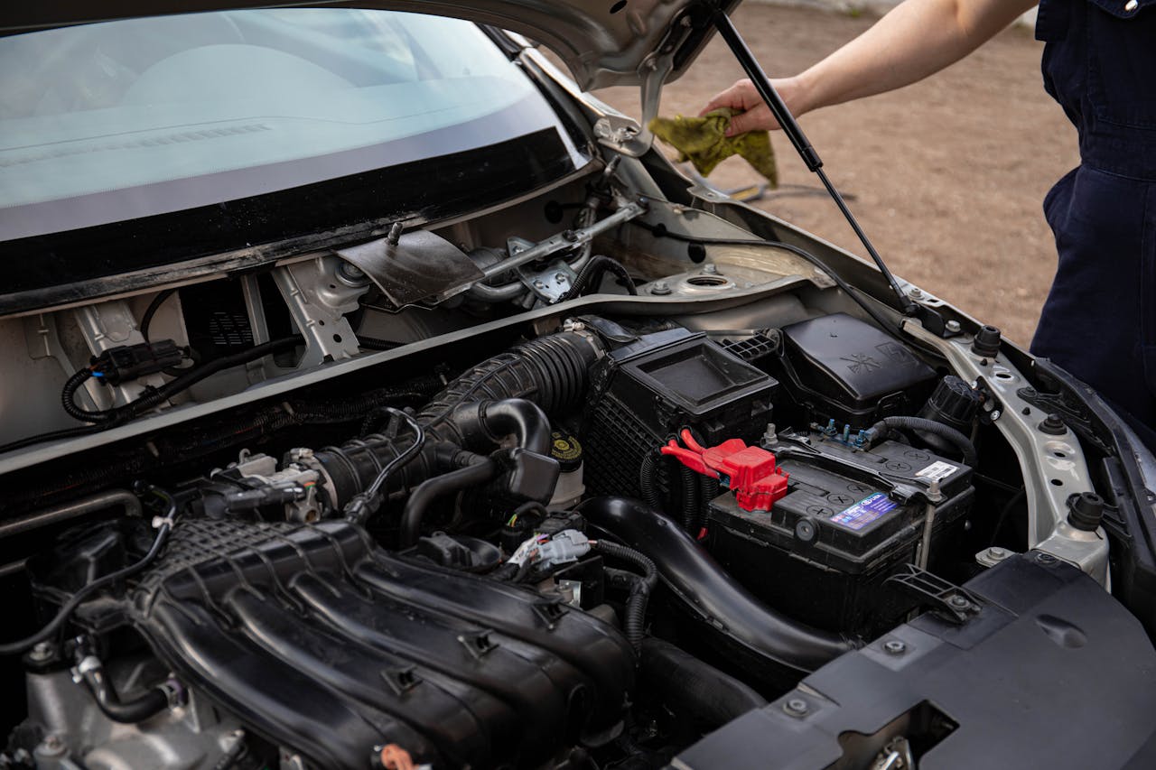 Mastering the First Impression: Your intriguing post title goes here Mechanic inspecting car engine bay and battery during routine maintenance.